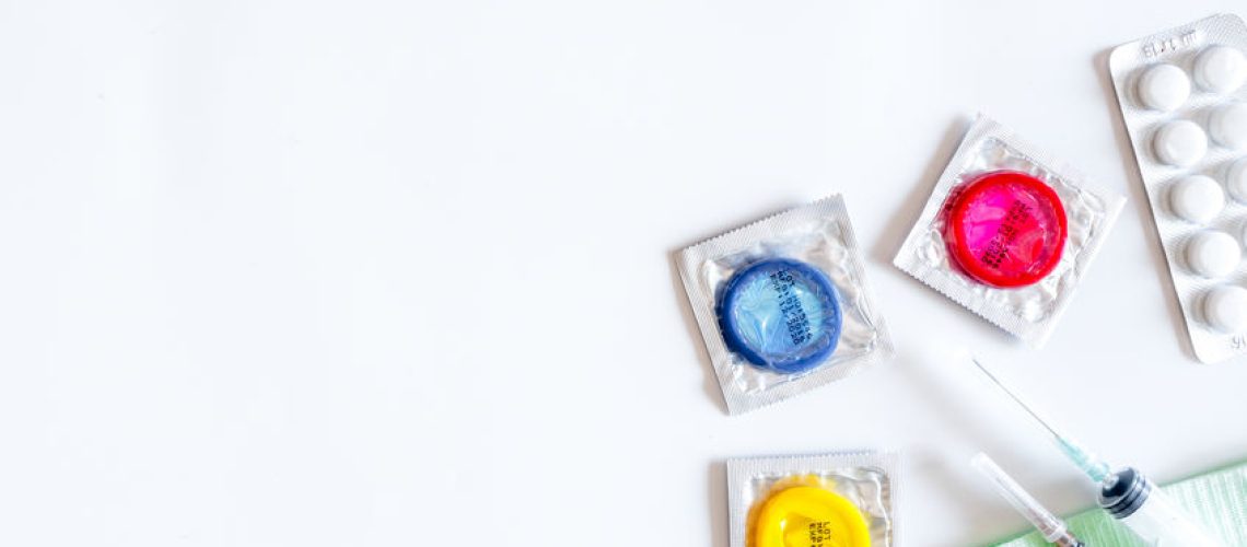 Visit the urologist. Tools and condoms on white background top view.