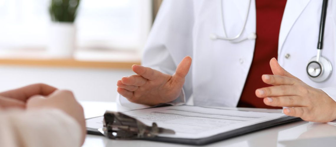 Hand of doctor  reassuring her female patient. Medical ethics and trust concept