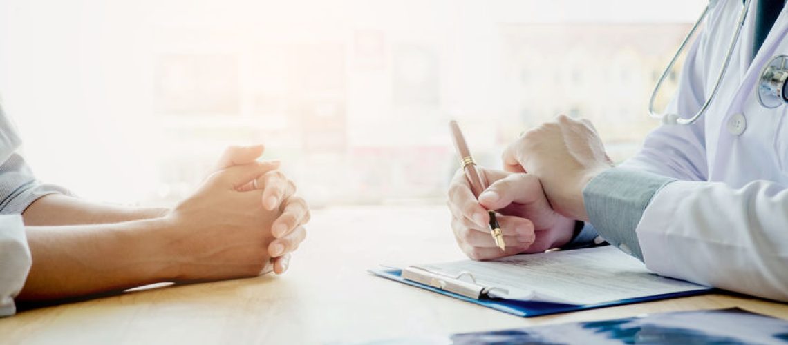 Doctors and patients sit and talk. At the table near the window in the hospital.