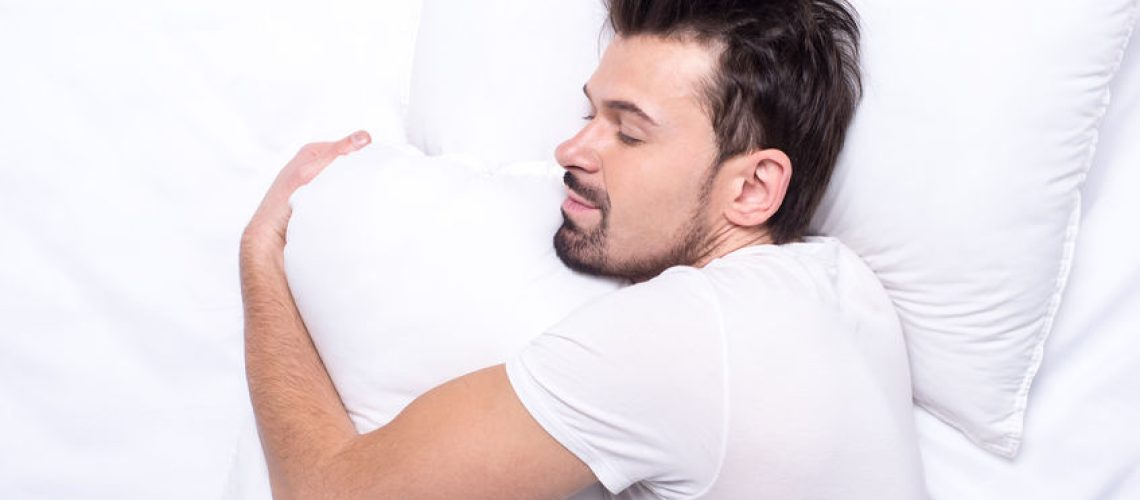 Top view of young man is sleeping in the bed.