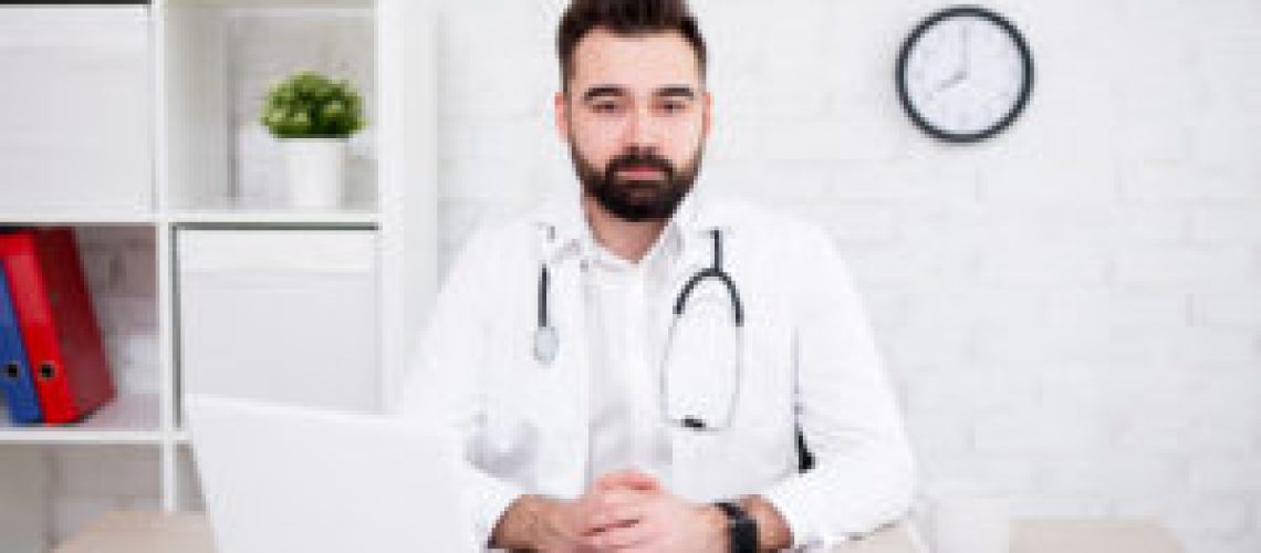 portrait of male doctor using laptop in modern office office
