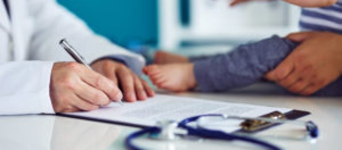 Male doctor with mother and her child in medical clinic